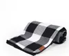 A folded picnic blanket with a black and white buffalo check pattern, lying on a white background. Anteprima dell’immagine prodotto
