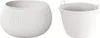 Two white planters are shown against a white background. The planter on the left is a round, knitted-look pot. The planter on the right is a simple, tapered pot with handles. Anteprima dell’immagine prodotto
