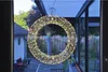A lit wreath hangs in front of a window overlooking a backyard. Produktbild-Vorschau
