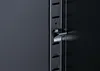 A close-up view of a metal latch mechanism on a black cabinet or furniture piece. Podgląd zdjęcia produktu