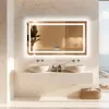 A modern bathroom with a large LED mirror, two sinks, and a view of the ocean. Podgląd zdjęcia produktu