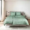 A neatly made bed with green and black striped bedding in a bright, modern bedroom. Produktbild-Vorschau