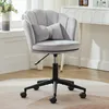 A gray velvet office chair with a scalloped back and a bow-shaped lumbar pillow is shown in a room with a desk and a vase of flowers. Produktbild-Vorschau