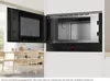 An open built-in microwave oven in a modern kitchen setting, with a dining area visible in the background. Voir les images du produit
