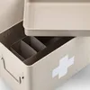 A close-up view of the interior and exterior of a beige metal medicine box with a white cross symbol. Náhled obrázku produktu