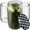 Three glass jars, one filled with pickles, and a checkered lid. Podgląd zdjęcia produktu