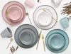 A collection of ceramic tableware in various colors, including plates, bowls, and mugs, arranged on a white background. Náhľad obrázku produktu