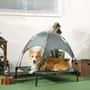 A corgi dog lies on a raised pet bed with a canopy, outdoors. Produktbild-Vorschau