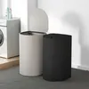 Two laundry baskets are shown in a laundry room setting next to a washing machine. Produktbild-Vorschau
