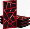 A stack of acoustic panels with a red geometric pattern on a black background, presented on a white surface. Podgląd zdjęcia produktu