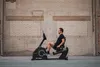A man is exercising on a recumbent exercise bike in front of a brick wall. Produktbild-Vorschau