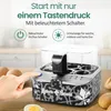 A hand is pressing a button on a Roberto Geissini branded egg cooker. There are eggs and bread rolls in the background. Produktbild-Vorschau