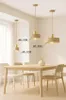 A dining table with chairs and pendant lights hanging above. Produktbild-Vorschau