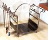 A metal firewood rack with a set of fireplace tools is shown in front of a stone wall and on a wooden floor. Podgląd zdjęcia produktu