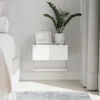 A white floating nightstand with a plant and picture frame on top, next to a bed and curtains. Náhled obrázku produktu