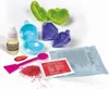 A collection of items for making lip balm, including molds, ingredients, and tools, laid out on a white surface. Náhled obrázku produktu