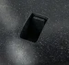 A close-up view of a black planter with a speckled texture and a rectangular opening. Voir les images du produit