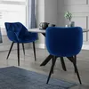 Two dark blue velvet dining chairs are shown around a round dining table in a dining room setting.