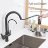 A black kitchen faucet with a pull-out hose is shown filling a pot in a sink. The background includes kitchen elements like bottles and a window. Náhľad obrázku produktu