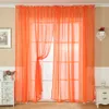 A room with orange sheer curtains covering a window, with furniture on either side. Produktbild-Vorschau
