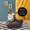 A woman and her dog are sitting on a beanbag sofa in a living room. Náhľad obrázku produktu