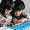 Two children are looking at a tablet computer. Produktbild-Vorschau