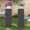 Two black plant stands with potted plants on them in a garden setting. Podgląd zdjęcia produktu