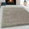 A shaggy rug in a living room setting with a fireplace and a stool. Náhľad obrázku produktu