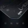 A close-up, angled view of a black gaming desk with futuristic design elements and icons at the bottom. Produktbild-Vorschau