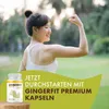 A woman flexing her arm in a park with a product bottle in the foreground. Produktbild-Vorschau