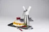 A whipped cream dispenser with a dessert and a glass of juice on a gray background. Produktbild-Vorschau