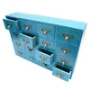 A bright blue wooden cabinet with 16 drawers, each featuring a brass pull handle and label holder. Some drawers are slightly open. Produktbild-Vorschau
