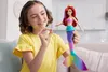 A young girl is holding a mermaid doll and a small toy. Anteprima dell’immagine prodotto