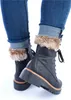 A close-up shot of a person's legs wearing blue jeans and black lace-up boots with fur trim. Anteprima dell’immagine prodotto