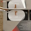 Two white ceramic washbasins with gold faucets are shown in a modern bathroom setting. Produktbild-Vorschau