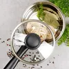 A top-down view of a pot with a glass lid, containing noodles and bay leaves, surrounded by peppercorns. Náhľad obrázku produktu