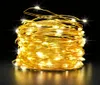 A coiled string of warm white LED lights on a flexible wire, presented against a dark background with reflections on a surface below. Náhľad obrázku produktu