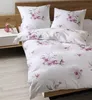 A neatly made bed with floral patterned bedding. Voir les images du produit