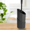 A black toilet brush holder with a toilet brush inside, placed on a wooden table. Anteprima dell’immagine prodotto