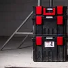 Stack of black Kistenberg organizer boxes with red clasps, placed on a concrete floor with a metal structure in the background. Anteprima dell’immagine prodotto