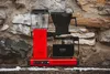 A red Moccacoffee maker sits on a stone ledge with snow. Náhled obrázku produktu