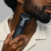 A person is trimming their beard with a black electric trimmer. Produktbild-Vorschau