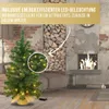 A decorated Christmas tree with lights in a cozy living room setting with a fireplace. Produktbild-Vorschau