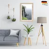 A living room scene with a sofa, a framed picture on the wall, and a floor lamp. Produktbild-Vorschau
