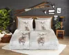 A bedroom scene with a bed dressed in a duvet cover featuring deer in a winter landscape. Produktbild-Vorschau