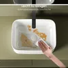 A hand is cleaning a white ceramic sink with a cloth, showing its easy-to-clean surface. Produktbild-Vorschau