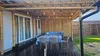 An outdoor patio area with a bamboo structure, furniture, and lighting. Náhľad obrázku produktu