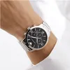 A close-up shot of a man's wrist wearing a silver Emporio Armani watch with a black face. Náhled obrázku produktu