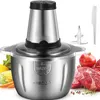 A stainless steel food processor is shown with raw ingredients like meat, corn, carrots, and pomegranates, along with a blade accessory and a knife. Produktbild-Vorschau