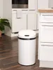 A white sensor trash can is placed on a wooden floor in a kitchen setting, next to white cabinets and a countertop. Produktbild-Vorschau